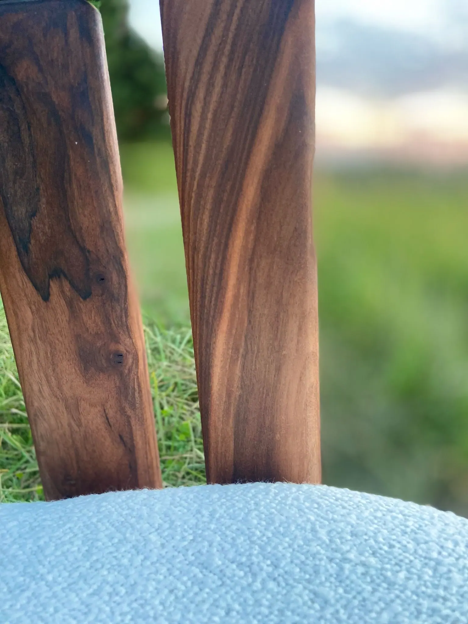 Détail du dossier d’un fauteuil en bois foncé, le veinage du bois